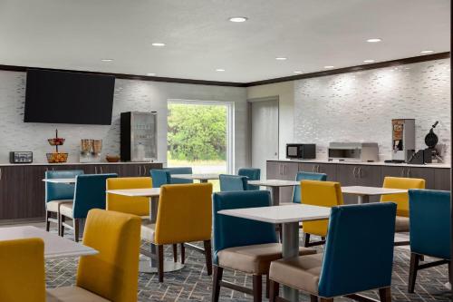 a dining room with tables and chairs and a tv at La Quinta Inn & Suites by Wyndham Peru Starved Rock St Park in Peru