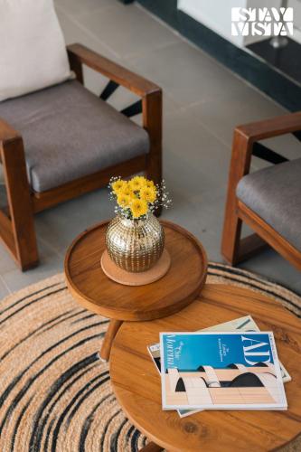 a coffee table with a vase of flowers on it at StayVista at Avyanna Villa - BBQ & Pool in Kārli