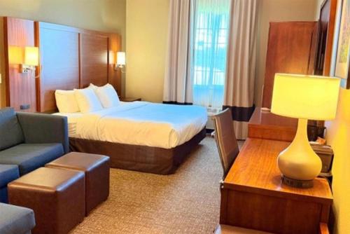 a hotel room with a bed and a couch at Hawthorn Extended Stay by Wyndham Amarillo in Soncy