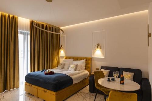 a bedroom with a bed and a table in a room at Hanza King Apartament 2 and SPA in Szczecin