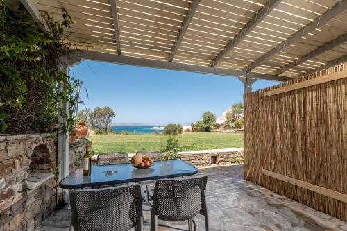 a patio with a blue table and chairs and a fence at Ydreos Studios & Apartments in Mikri Vigla