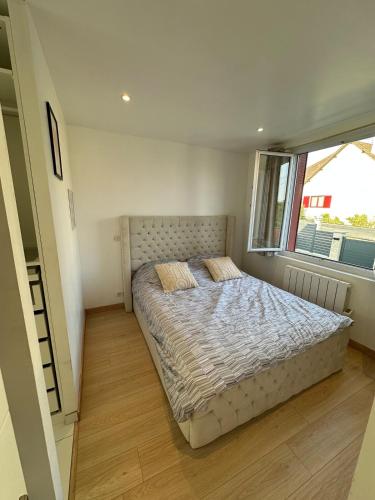 a bed in a bedroom with a large window at Maison 1 chambre Jacuzzi Privé in Savigny-sur-Orge