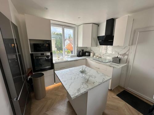 une cuisine blanche avec un comptoir et une fenêtre dans l'établissement Maison 1 chambre Jacuzzi Privé, à Savigny-sur-Orge