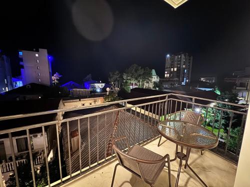 a table and chairs on a balcony at night at Nina two in K'obulet'i