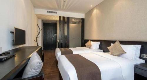 a hotel room with two beds and a desk at H Life Hotel Nanshan Branch in Shenzhen