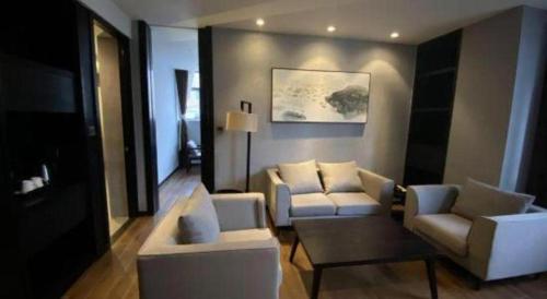a living room with a couch and two chairs and a table at H Life Hotel Nanshan Branch in Shenzhen