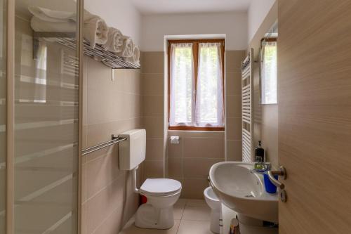 a small bathroom with a toilet and a sink at Infinity View Garda lake in Tenno