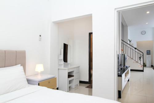 バンドンにあるVilla Normandieのベッドとテレビのある白い寝室