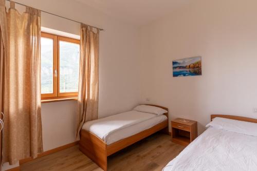 a small bedroom with two beds and a window at Infinity View Garda lake in Tenno