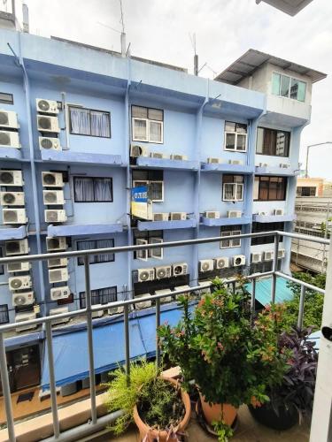a blue building with potted plants on a balcony at Cloud no 4 Green n Quiet Heart BKK With a Balcony in Bangkok