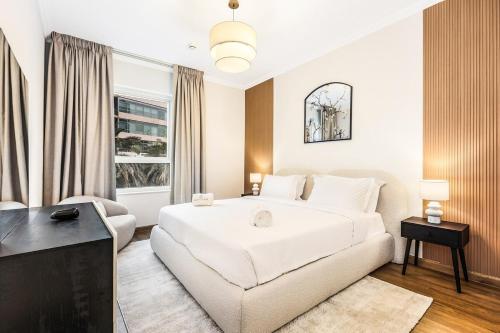 a bedroom with a large white bed and a couch at Luxury 2BR Dubai Marina Apartment Walk to JBR Beach & Marina Yacht Club in Dubai