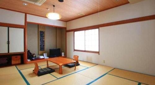 a living room with a table and chairs in it at Hotel Honjin in Kumamoto