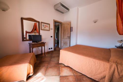 a hotel room with two beds and a television at Principe di Aragona in Aragona