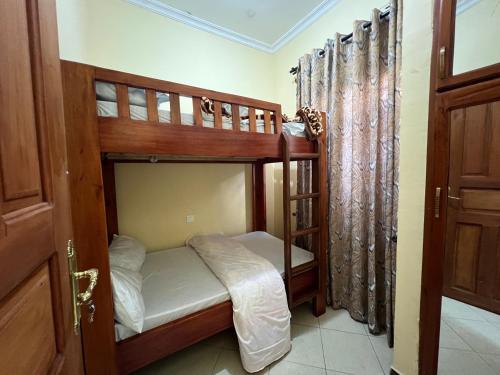 a bedroom with two bunk beds and a door at Beego Homestay in Ngateu