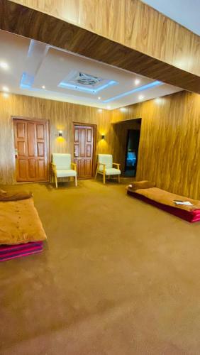 a large room with two beds and two chairs at Biafo Resort Skardu in Skardu