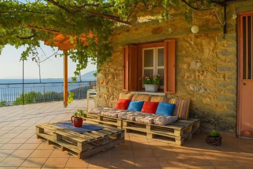 a bench sitting on the porch of a house at Coastal Stone Residence with Spectacular Scenery in Kitriaí