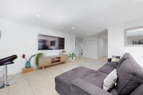 a living room with a couch and a tv at Pacific Pines 3BR Peaceful Home Stay in Gold Coast