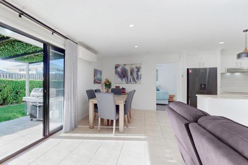 a kitchen and living room with a table and a couch at Pacific Pines 3BR Peaceful Home Stay in Gold Coast