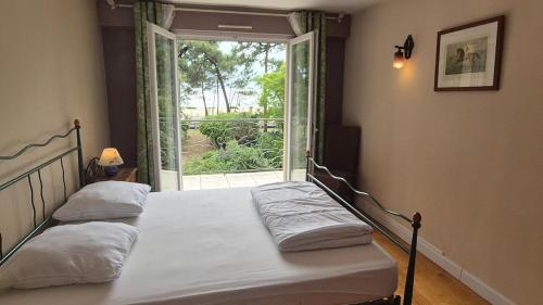 une chambre avec deux lits et une grande fenêtre dans l'établissement Villa face mer, plage, à Saint-Georges-de-Didonne