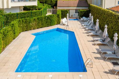 une piscine bleue avec chaises longues et parasols dans l'établissement Bellevue Cannes, à Cannes