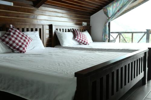 two twin beds in a room with a window at Roses Homestay- Venuestay in Tam Ðảo