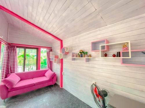 a pink couch in a room with a window at Roses Homestay- Venuestay in Tam Ðảo