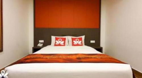 a bedroom with a large bed with red pillows at Capital O 90574 Hotel Glo in Kuala Lumpur