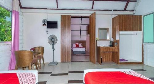 a room with a bedroom with a bed and a desk at Dreamland Beach Holiday in Kudat