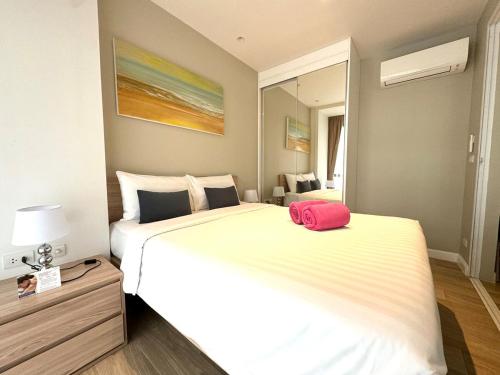 a large white bed with a pink bag on it at Diamond condo apart Bangtao beach in Bang Tao Beach