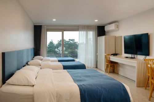 a group of four beds in a hotel room at Hallim Resort in Jeju