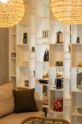 a living room with white shelves with potted plants at My Nafpaktos Resort in Nafpaktos