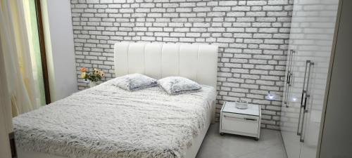 een slaapkamer met een bed en een bakstenen muur bij Luxury Sunrise Complex Apartment in Goudstrand