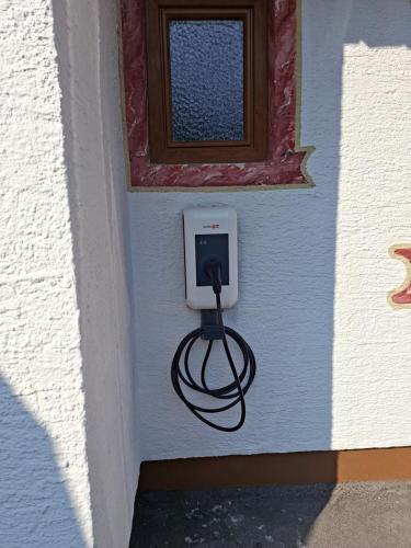 a cord plugged into a outlet on a wall at Gästehaus Haag in Ehrwald