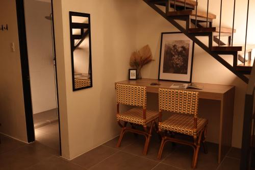 a room with a desk with two chairs and a mirror at Casa Charlie B&B in Manila