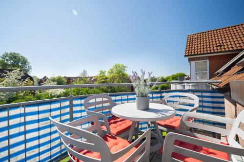 Un patio con una mesa y sillas en un balcón. en Am Golfplatz 25 Elma, en Stakendorfer Strand