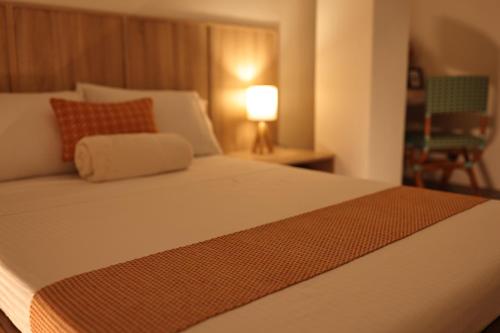 a bedroom with a bed with a lamp and a chair at Casa Charlie B&B in Manila