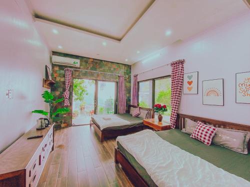 a bedroom with two beds and a large window at Roses Homestay- Venuestay in Tam Ðảo
