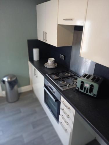 a kitchen with a stove and white cabinets at Adorable Villa in Hull