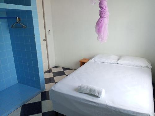 a bedroom with a bed and a shower with a towel at Christina's Guest House OFFICIAL in Little Corn Island