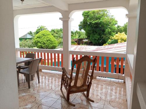 a porch with a rocking chair and a table at Christina's Guest House OFFICIAL in Little Corn Island
