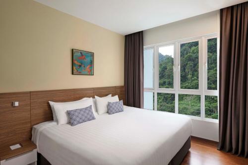 a bedroom with a large bed and a large window at TUI BLUE The Haven Ipoh in Ipoh