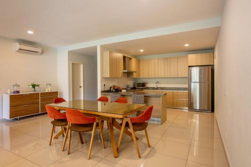 a kitchen with a wooden table and red chairs at TUI BLUE The Haven Ipoh in Ipoh