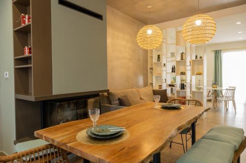 a dining room and living room with a wooden table at My Nafpaktos Resort in Nafpaktos