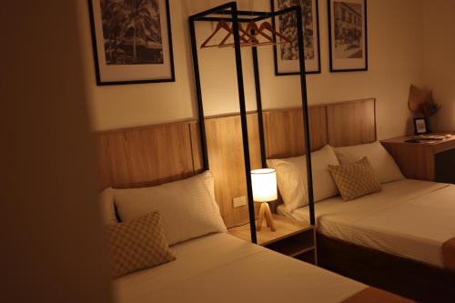 a hotel room with two beds and a lamp at Casa Charlie B&B in Manila