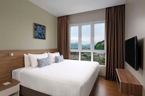 a bedroom with a large bed and a large window at TUI BLUE The Haven Ipoh in Ipoh