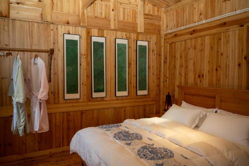 a bedroom with wooden walls and a bed and windows at Celestial Valley in Zhangjiajie