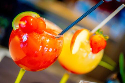 two cocktails with fruit on sticks on a table at Campanile Pontarlier in Pontarlier