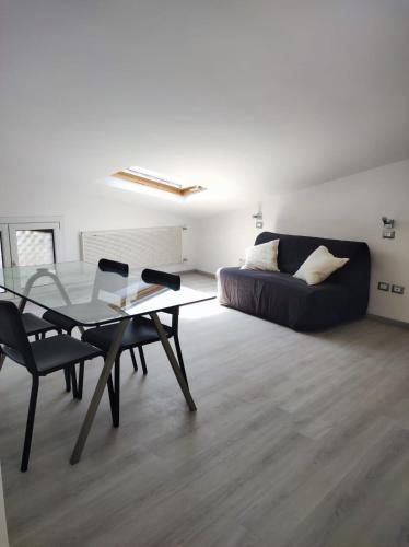 a living room with a glass table and a couch at La mansarda del Panfilo in Cervia