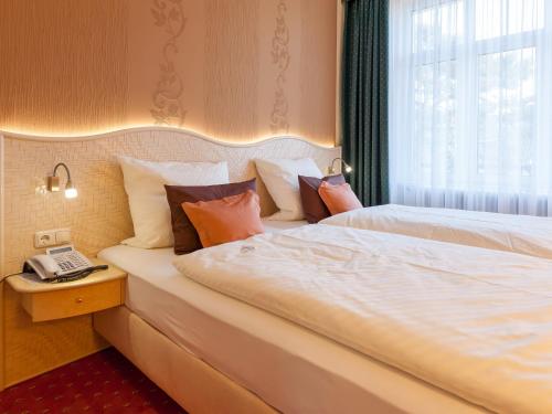 ティメンドルファー・シュトラントにあるPark-Hotelのベッド2台、電話が備わるホテルルームです。
