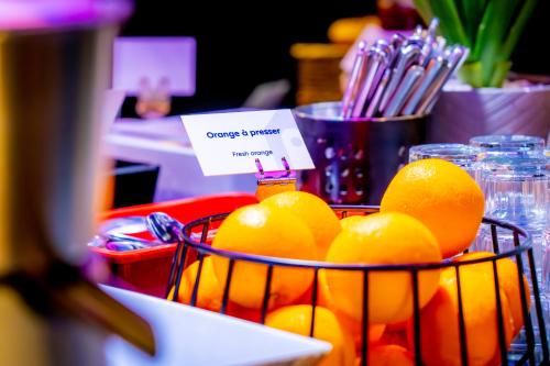 a basket of oranges sitting on a table at Campanile Pontarlier in Pontarlier